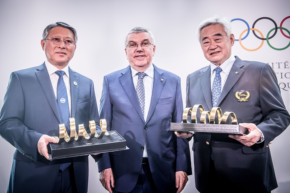 ITF 리용선 총재(왼쪽)와 WT 조정원 총재(오른쪽)가 IOC 토마스 바흐 위원장(가운데)이 준비한 올림픽 트로피 기념품을 들고 기념사진 촬영을 하고있다.